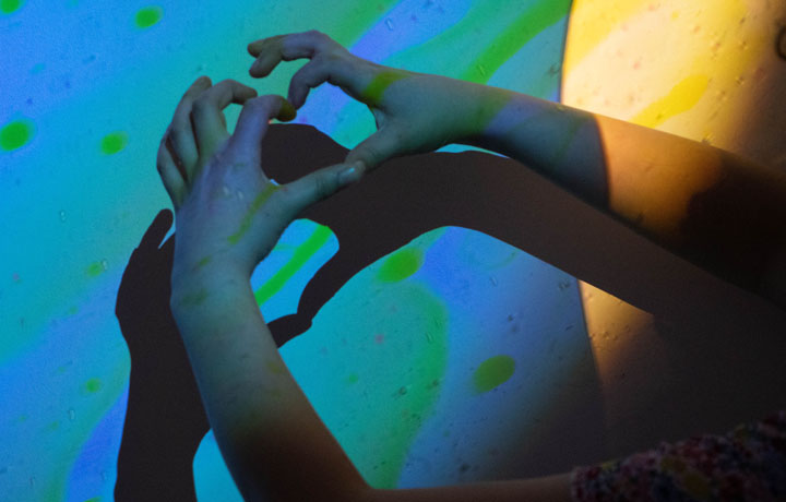 Hände, die ein Herzzeichen als Schatten an der Wand der Clinicoeurs-NGO bilden