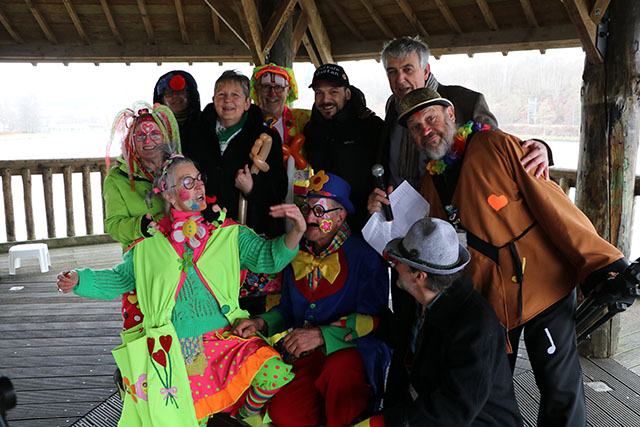 Plusieurs bénévoles cliniclowns souriant avec le parrain de l'ASBL Cliniclowns devant l'ASBL