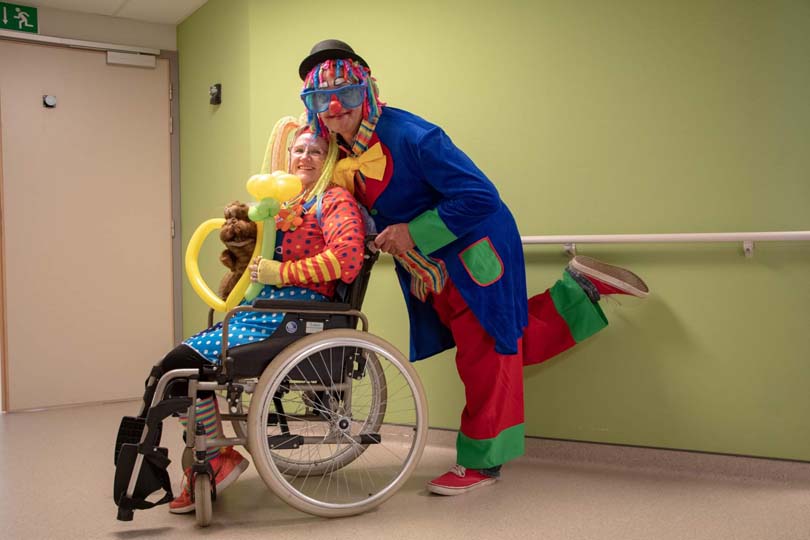 Deux bénévoles déguisée en clown, le premier en chaise roulante et le deuxième le poussant