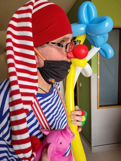 Une bénévole déguisée en clown avec un bonnet rouget et un t-shirt bleu