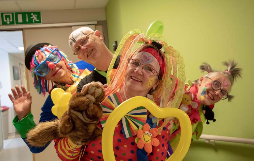 4 bénévoles déguisé en clowns avec un coeur jaune au milieu