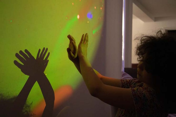 Les mains d'une fille formant des signes sur les murs avec des couleurs vertes